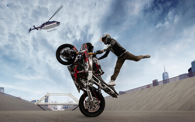 Moto rider making a stunt on his motorbike. Biker doing a difficult and dangerous stunt.