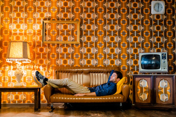 Man lying on couch in vintage living room