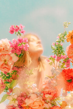 Beautiful woman with flowers behind glass pane