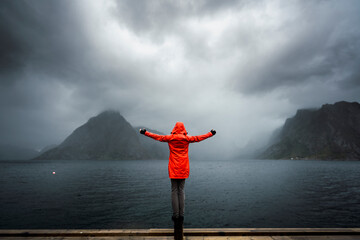 Norway, Lofoten, rear view of man balancing on a pole at the coast