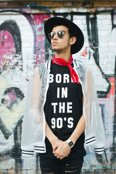 Fashionable young man with hat and sunglasses wearing t-shirt with saying 'Born in the 90s'