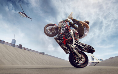 Moto rider making a stunt on his motorbike. Biker doing a difficult and dangerous stunt.