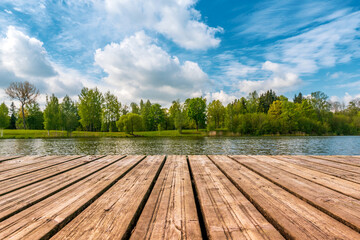 Fototapeta na wymiar Wooden pier in the lake with forest scenery background