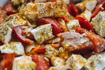 Salad with fresh tomatoes, feta cheese, olive oil and spices. Delicious light summer vegetable salad for lunch.