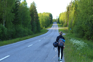 hitch-hiking girl walking on the road