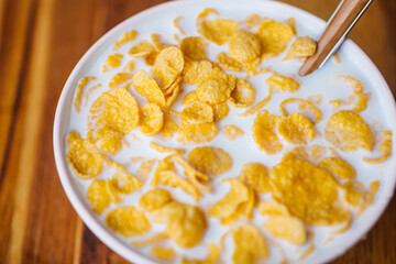 Breakfast cereal with milk on a wooden kitchen table. Healthy breakfast background