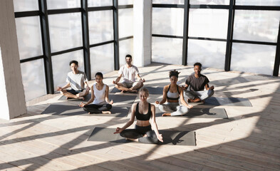 Multiethnic Group Of People Sitting In Lotus Position, Making Meditation Exercises