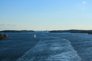 Boat in the ocean with the trace from the cruise ship