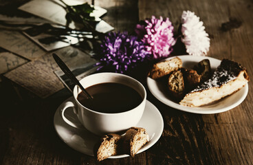 Cup of hot chocolate, cookies and flowers on an old wooden table
