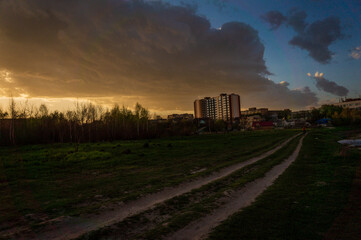 Fototapeta na wymiar Green meadow under sunset sky with clouds