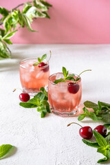 Mocktail with pink syrup and sweetened cherry