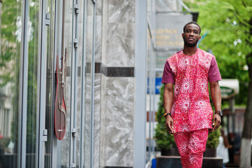 Portrait of a black young man wearing african traditional red colorful clothes.