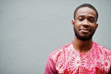 Portrait of a black young man wearing african traditional red colorful clothes.
