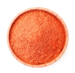 Red ground pepper in a wooden plate on a white. Top view.