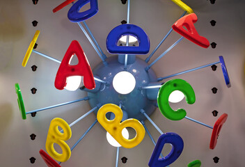 Children's chandelier with colored letters of the English alphabet.