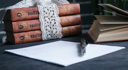 Book and black note with pen. Literature for the holidays and summer. Notes and quotes. Books on the dark table.