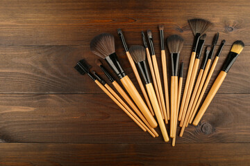 background with makeup brushes top   view on dark wooden surface