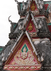 Multil-level roof top of a temple building in showing several praying buddha images in a temple site in SIamese Lao PDR, Southeast asia