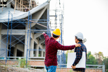 Two construction engineers Check the construction concept of the engineer and architect, work at the construction site with blue printing