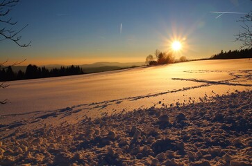 Picturesque sunset over a snowy mountain meadow.
