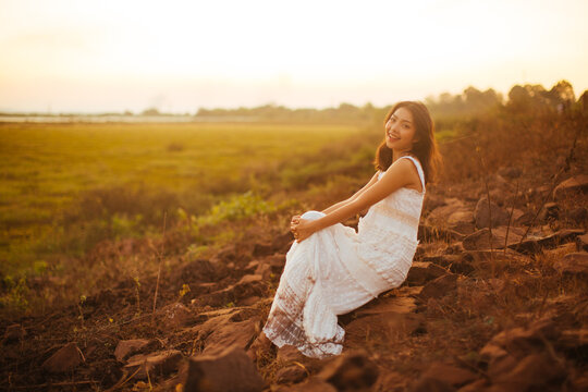 Portrait of beautiful woman smiling at park during sunset. Outdoor portrait of a smiling asian woman.
