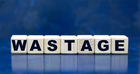 concept word WASTAGE on cubes on a blue background