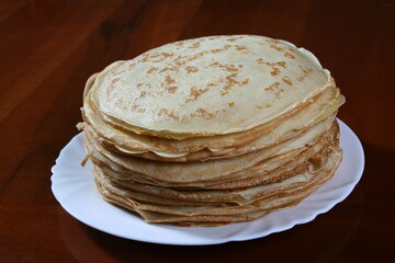 Thin pancakes on a white plate