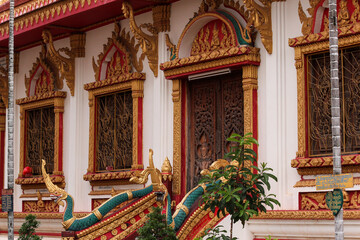 Tip of a stony and golden painted stupa in front of a religious wooden monks building or home in Siamese Lao PDR, Southeast Asia