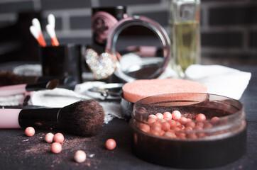 Cosmetics on a dark background, close-up. Face care, make-up. Items for applying makeup. The world of a woman.