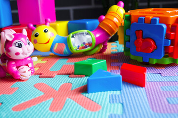 Educational children's bright toys on the table. Puzzles, rattles, cubes and mechanical squirrel. Toys zero and older. Child's world.