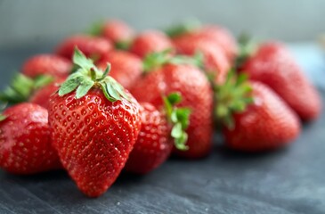 Fresh ripe delicious strawberries on black and grey background. Selective focus. Concepts of strawberry season.
