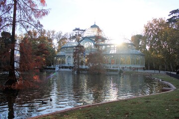 Fototapeta premium Vista del Palacio de Cristal del parque del Retiro con su estanque en otoño