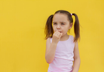 a cheerful girl of 4-5 years old eats fresh strawberries in the fresh air. Summer season. Childhood. Isolated yellow background