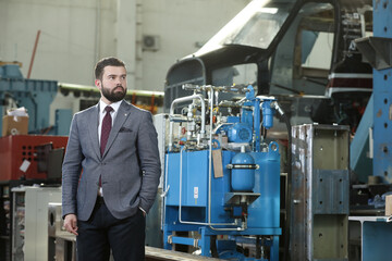 Portrait of a solid businessman controlling work process in a airplane manufactory. 