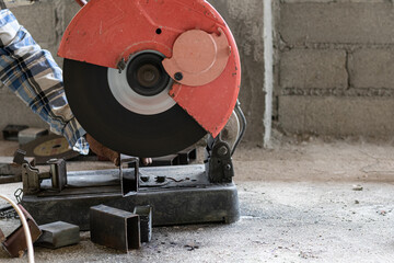 Professional mechanic is cutting steel metal with rotating diamond blade cutter. - Industry concept.