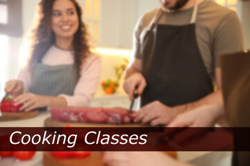Cooking classes. Blurred view of people cutting meat and vegetables in kitchen