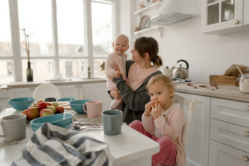 A young mother spends time with her little daughters at home.