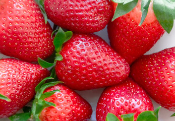 Fresh red strawberry stack close-up on a white background