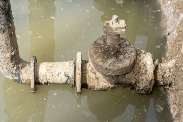Used muddy water pipe valve in a trench
