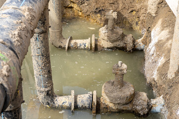 Used muddy water pipe valve in a trench