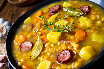 Rustic pea soup with bacon and sausages