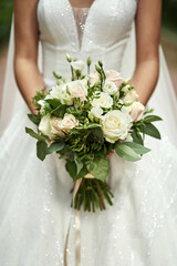 bouquet in hands of the bride, woman getting ready before wedding ceremony