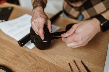 Close up shot of young adult man hands assembling new furniture at home.