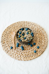 oatmeal porridge in bowl with fresh blueberries.Healthy vegan Breakfast cereals, against background of brown natural seaweed napkin,natural wooden bamboo spoon.Concept of clean food,healthy lifestyle