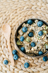oatmeal porridge in a bowl with fresh blueberries. Healthy vegan Breakfast cereal,on a background of natural brown napkins from the dry algae. Concept of clean food, healthy lifestyle.vegan food