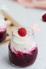 Close up smoothie from raspberry with milk in glass jar at light gray background