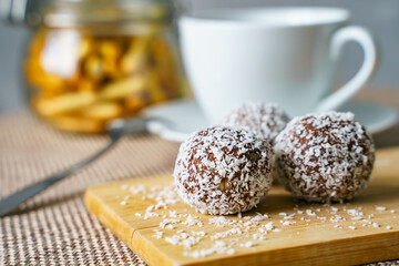 Tasty candies with coconut on a wooden board. Healthy and tasty breakfast