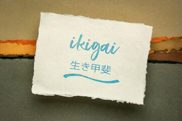 ikigai - Japanese philosophy and life style  - a reason for being or a reason to wake up  - handwriting on a handmade rag paper against abstract landscape
