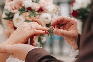Engagement, wedding, man and woman dress each other rings. Bride and groom. Hands, wedding gold rings with diamonds.