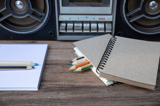 Closeup of drawing books and color pencils placed in front of the tape player